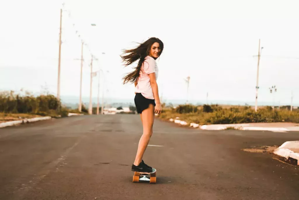 Skateboarding freedom: A woman confidently rides her skateboard on the road, embodying the spirit of urban skateboarding and carefree movement.